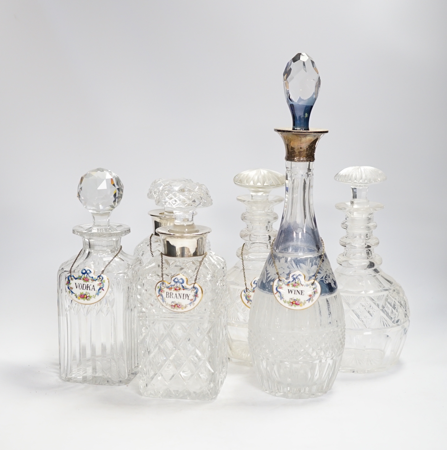 A pair of silver mounted decanters and four other decanters, five with Staffordshire decanter labels, largest 40cm high